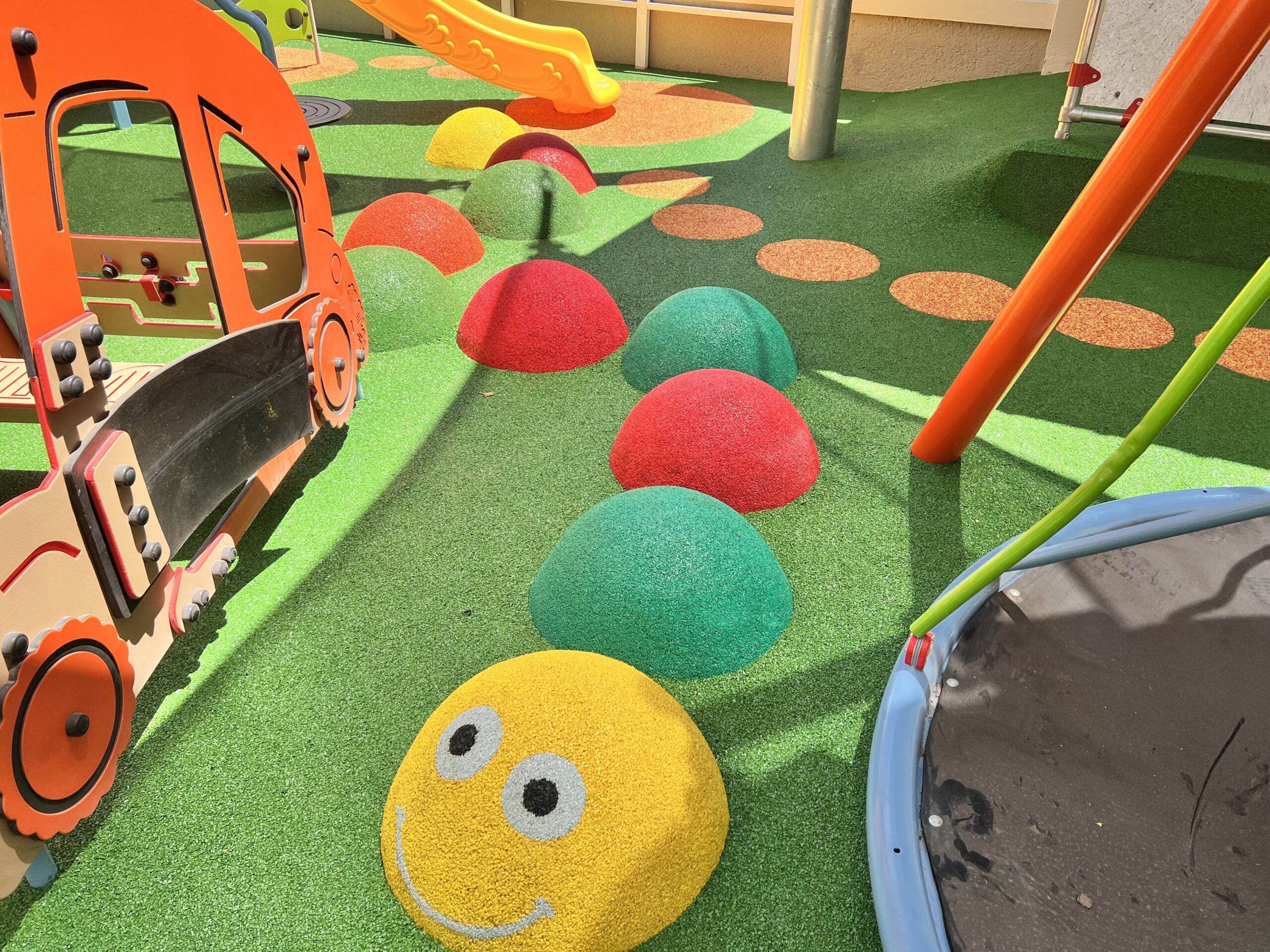 Vibrant blue wet-pour safety flooring newly installed in an outdoor playground